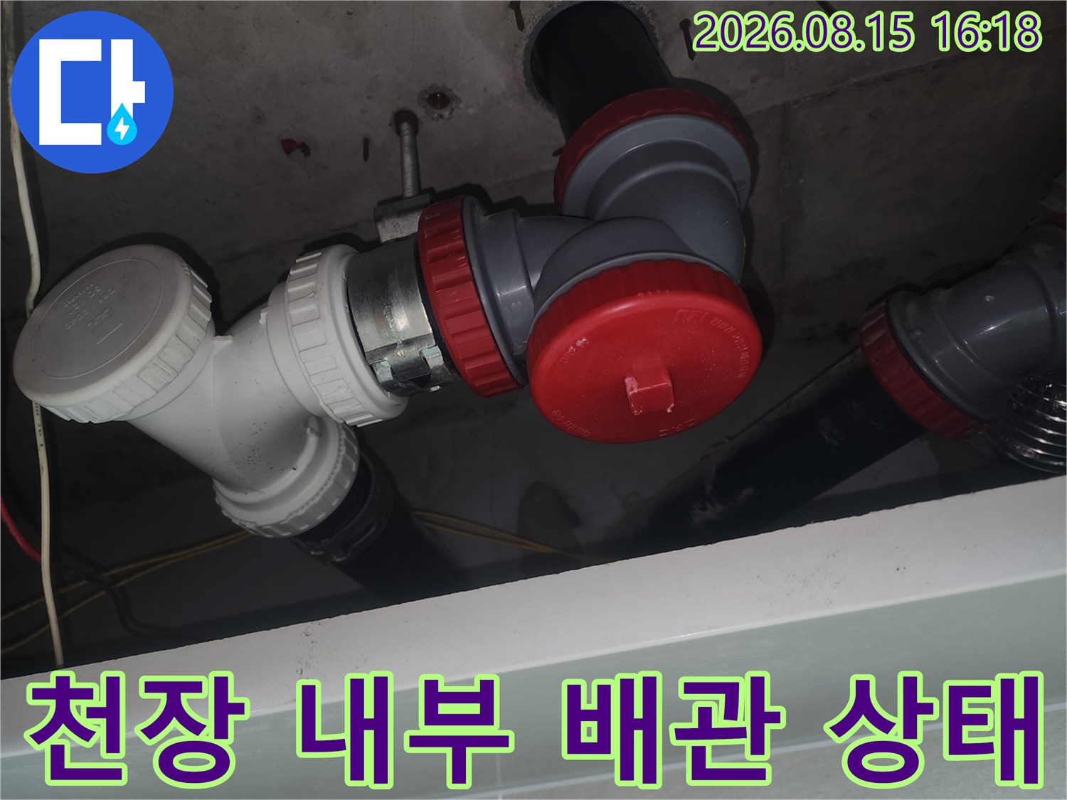 화장실 천장 속-하수관 연결 부위와 붉은색 소재구 마감재 모습입니다.