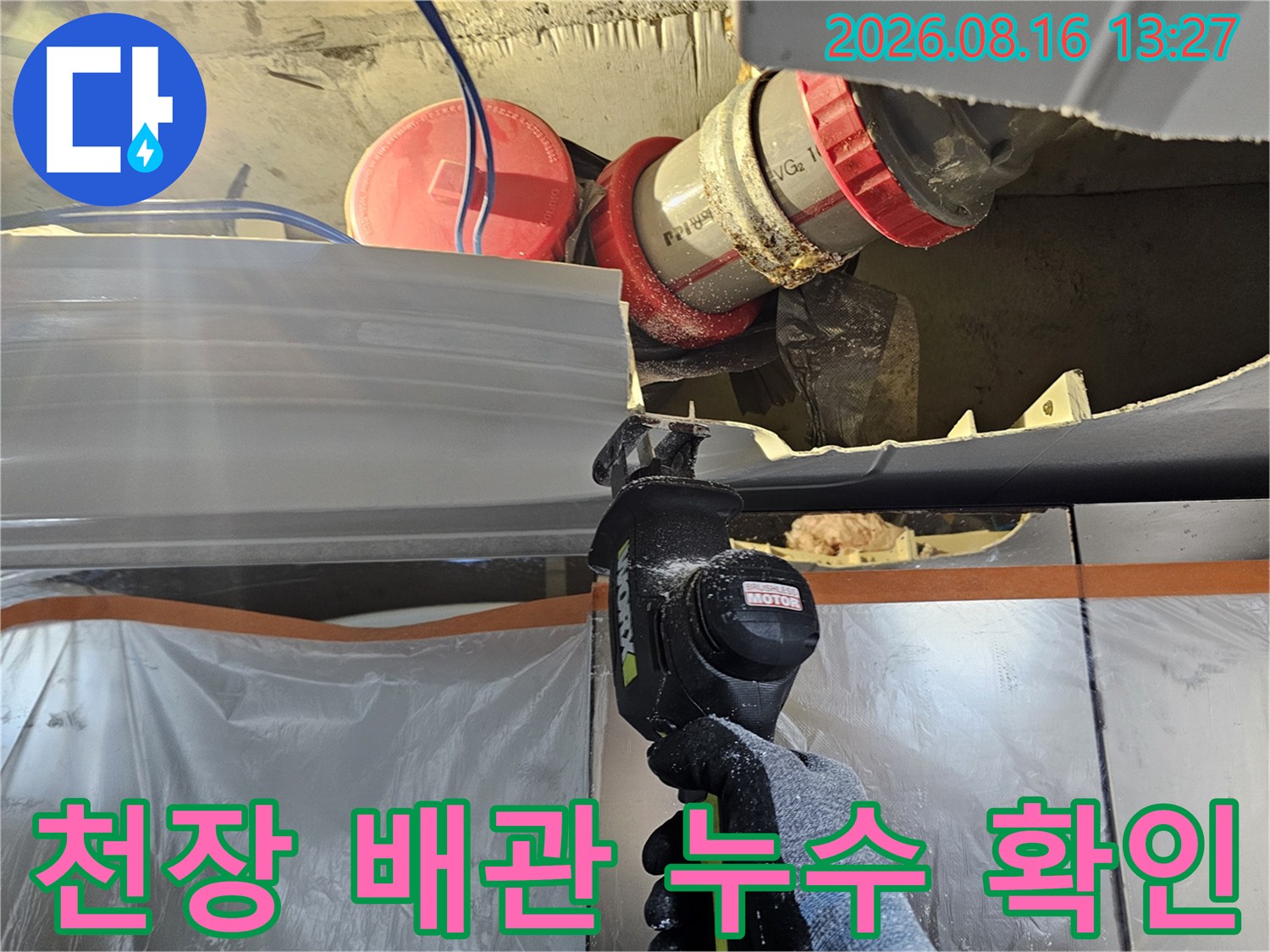 하수 배관의 붉은색 연결 부속과 천장 구조물을 촬영한 사진입니다.