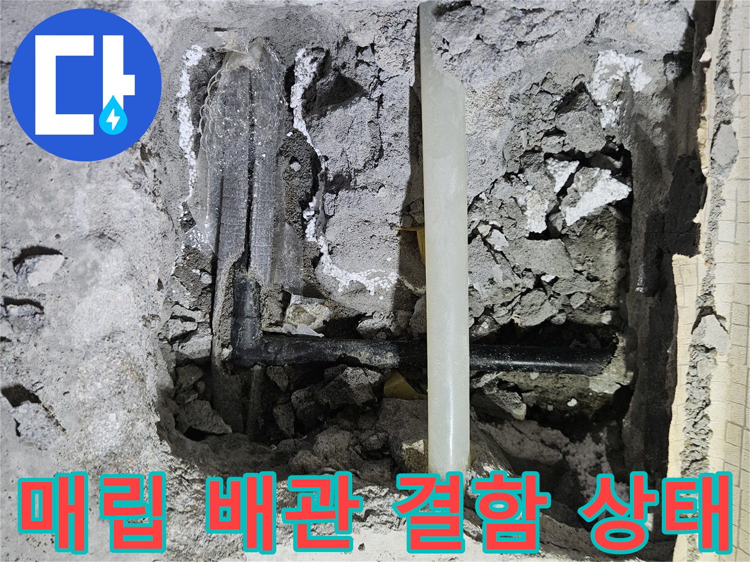 콘크리트 굴착 부위-물이 새어 나오는 검은색 배관의 모습