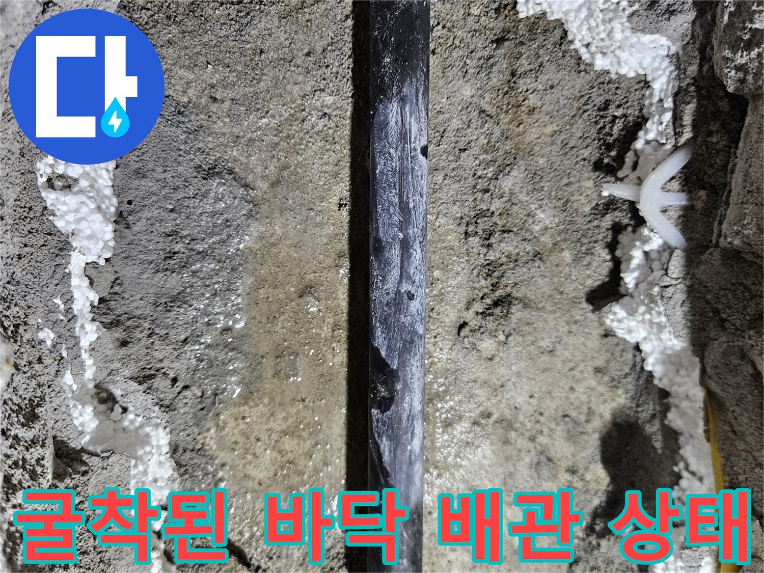 흙과 콘크리트 사이-물기가 보이는 매립 배관