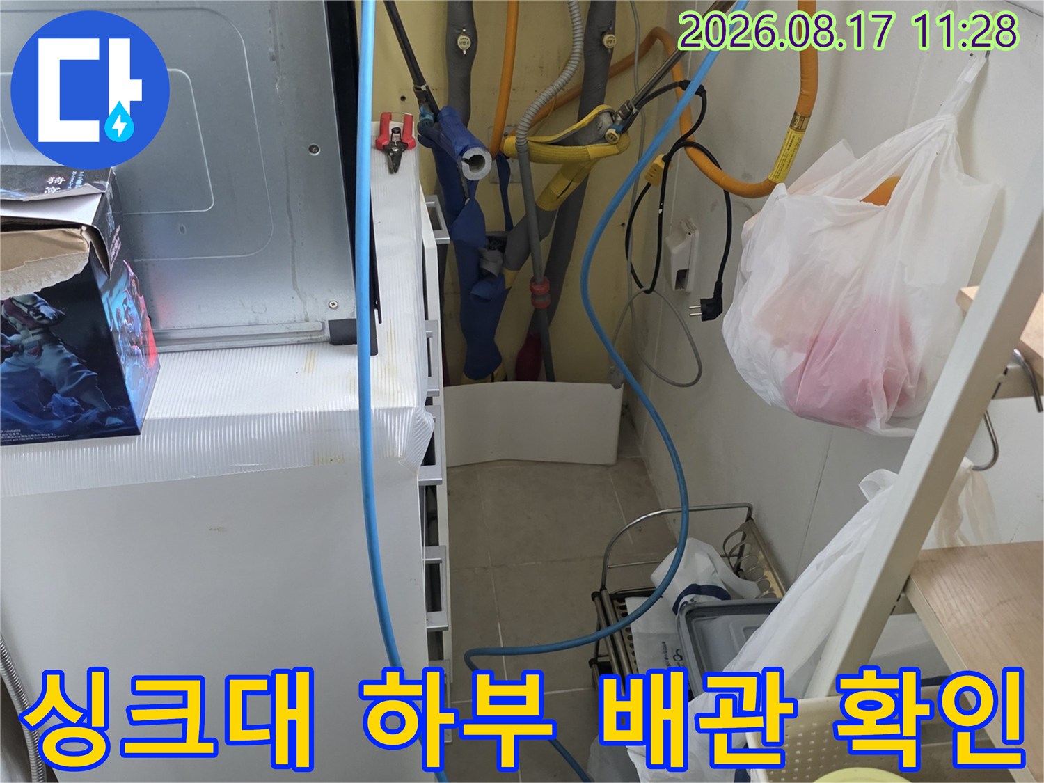 주방 싱크대 아래쪽 수도 배관과 정수기 호스 연결 상태