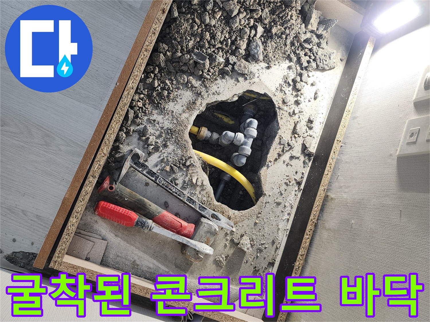 배관 수리를 위해 함마드릴로 파헤친 세탁실 바닥 굴착 부위