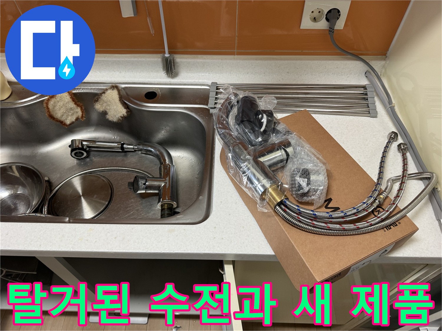 기존에 사용하던 낡은 싱크대 배관과 새로 교체할 새 수전 세트가 놓여 있는 모습