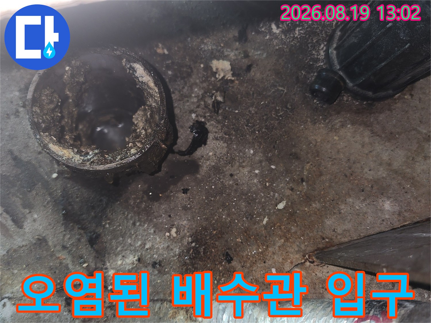 배수관 입구 주변에 찌든 이물질과 물 자국이 남아있는 모습입니다.