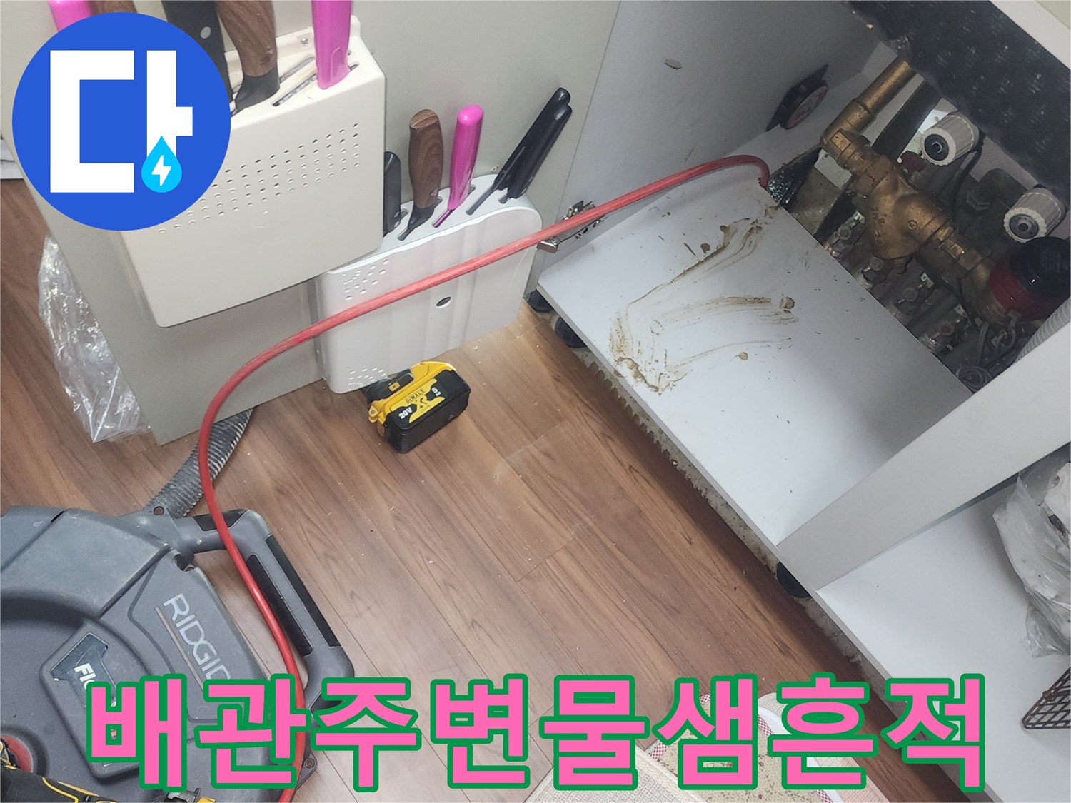 싱크대 아래 배관 주변의 젖은 바닥과 장비 구성