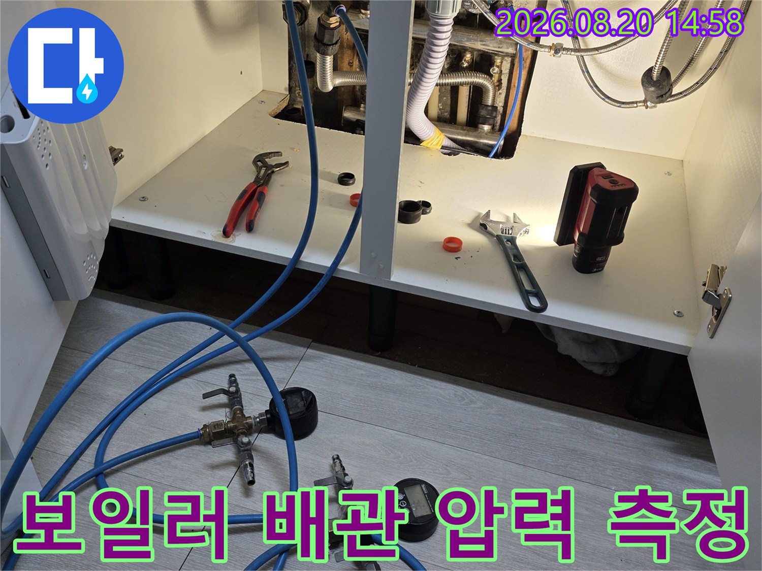 분배기 주변에 설치된 압력 게이지와 연결 호스를 통한 누수 점검 장면입니다.