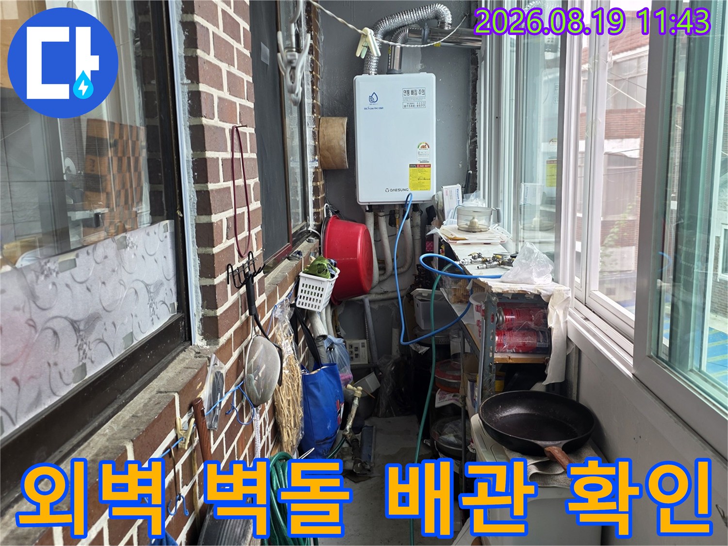 붉은 벽돌 외벽과 외부로 노출된 보일러 배관의 상태를 촬영하였습니다.