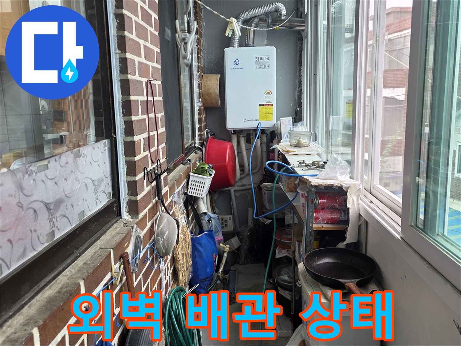 붉은 벽돌 외벽에 설치된 흰색 배관과 외부 설비 시설물