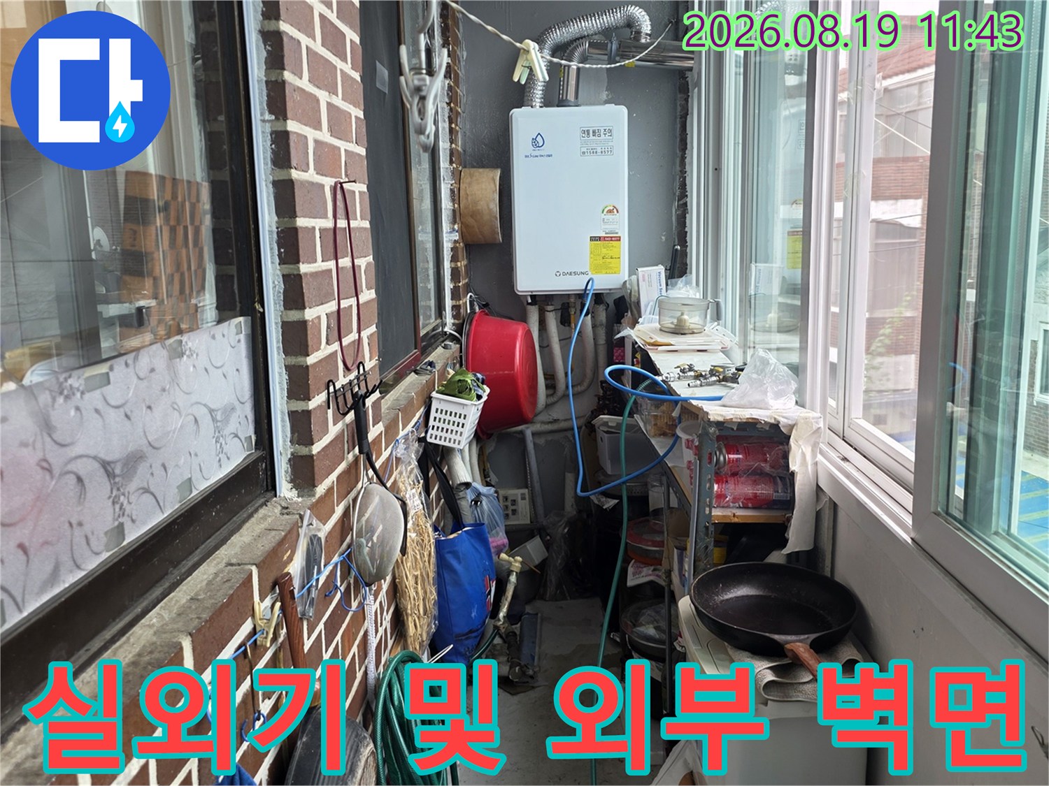 실외기 주변의 노출된 배관과 벽돌 외벽 모습