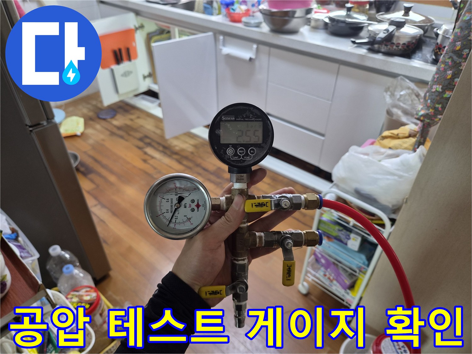 배관 연결 부위에 압력 측정기를 설치하여 수치를 모니터링하는 장면