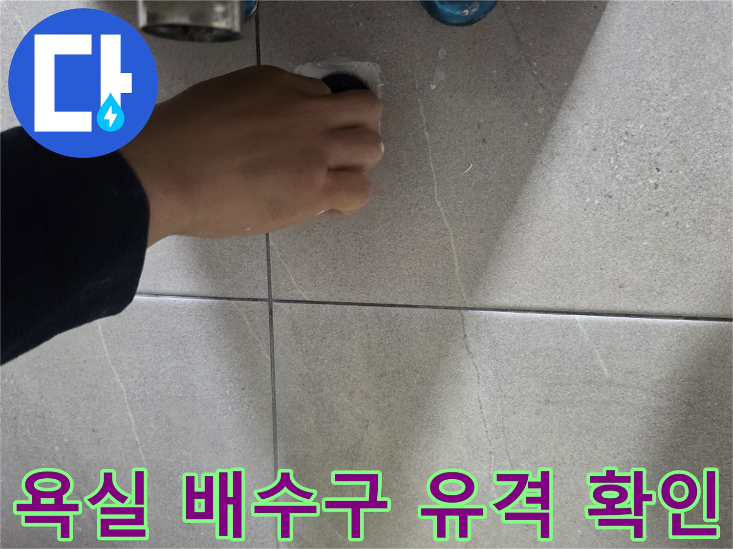 손으로 배수구 주변 타일 접촉면을 살피는 사진