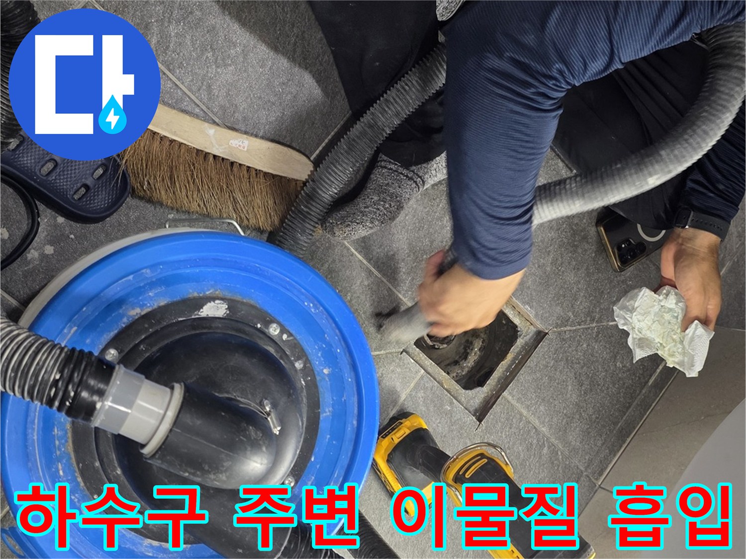 청소기를-사용해-배수구-주변의-오물을-제거하는-공사-현장