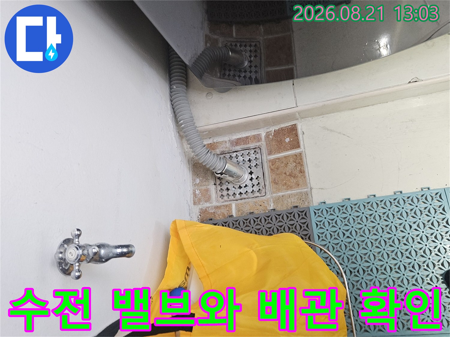 싱크대 하단 수전 밸브와 주름진 배관이 연결된 현장 사진입니다.