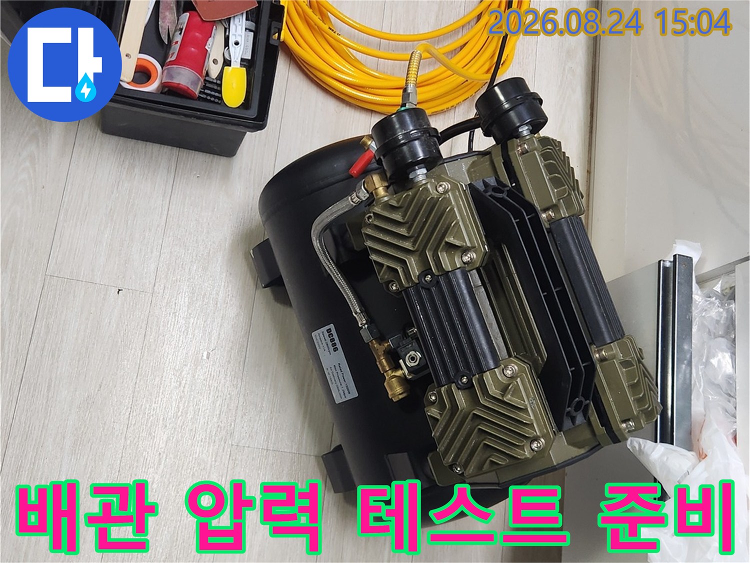 검사용 콤프레셔와 노란색 에어 호스가 놓인 작업 현장 모습