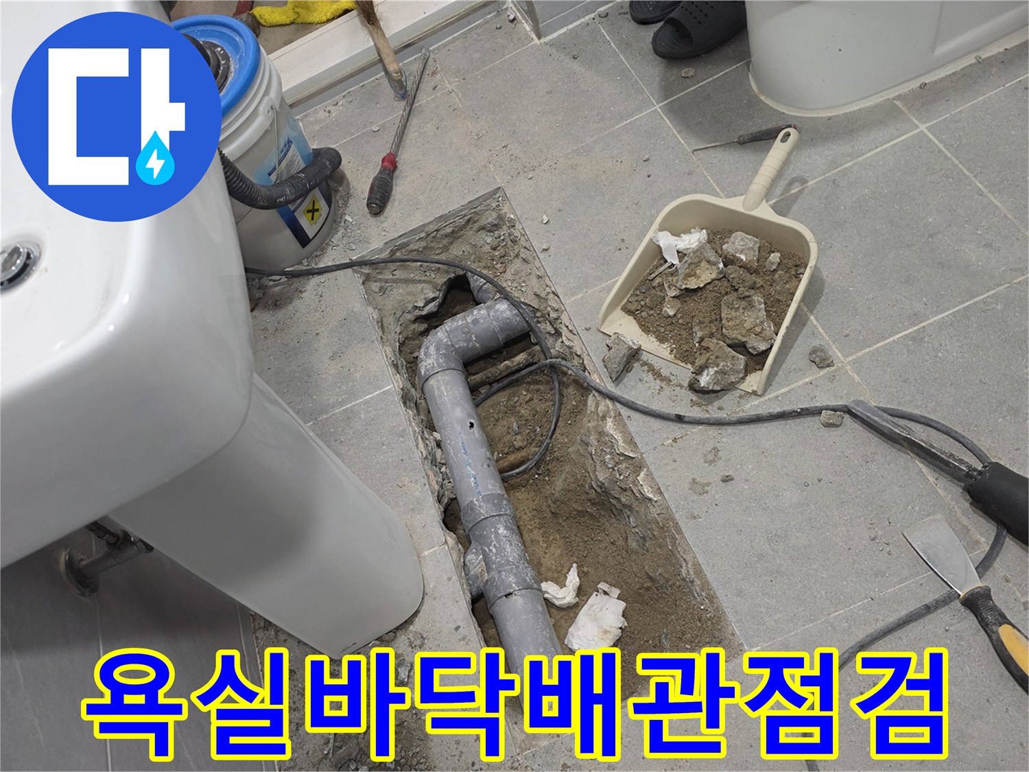 타일을 제거하고 드러난 배관의 파손 상태를 보여줍니다.