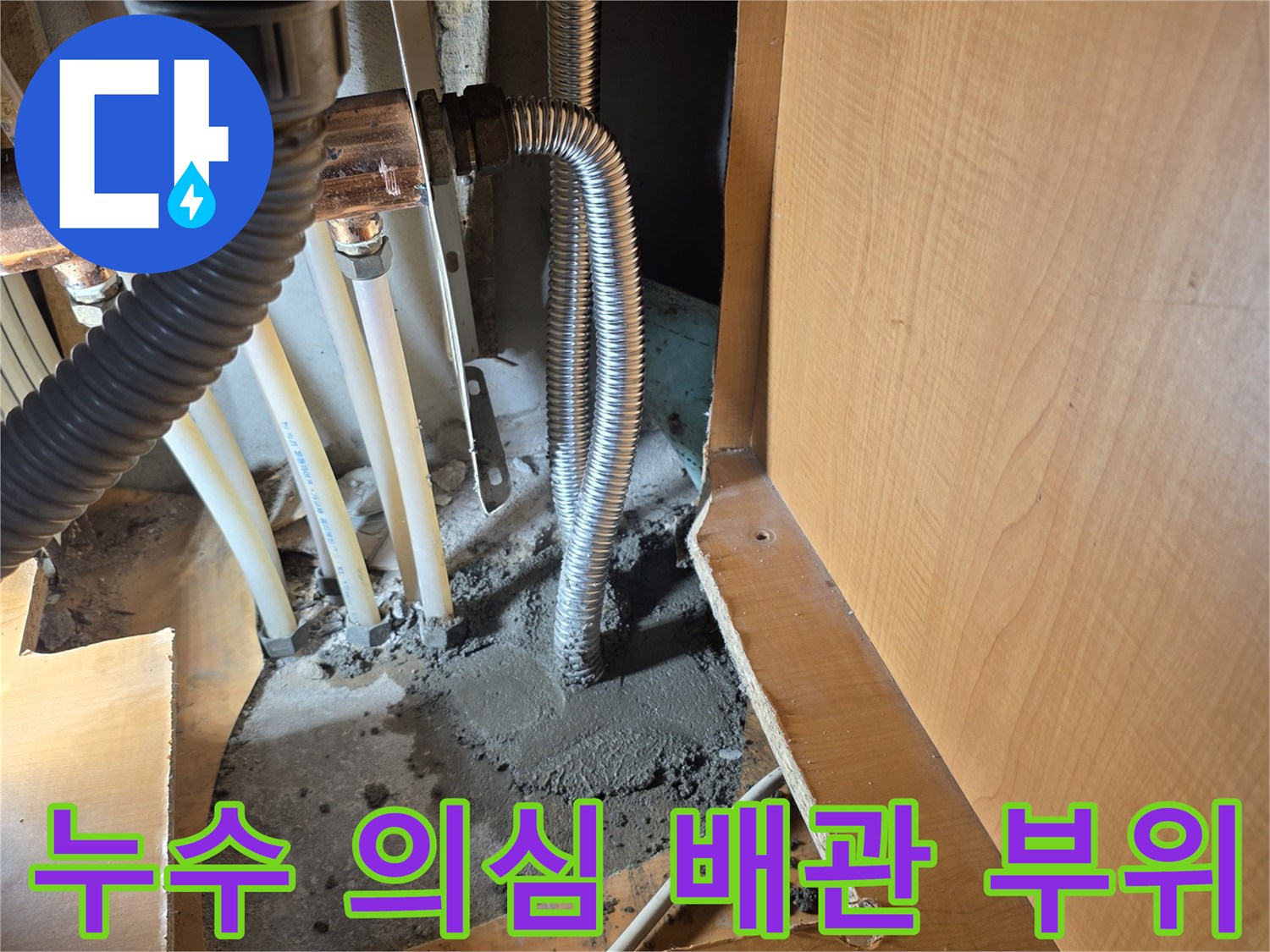 싱크대 하단 굴착 부위의 젖은 콘크리트와 금속 관로