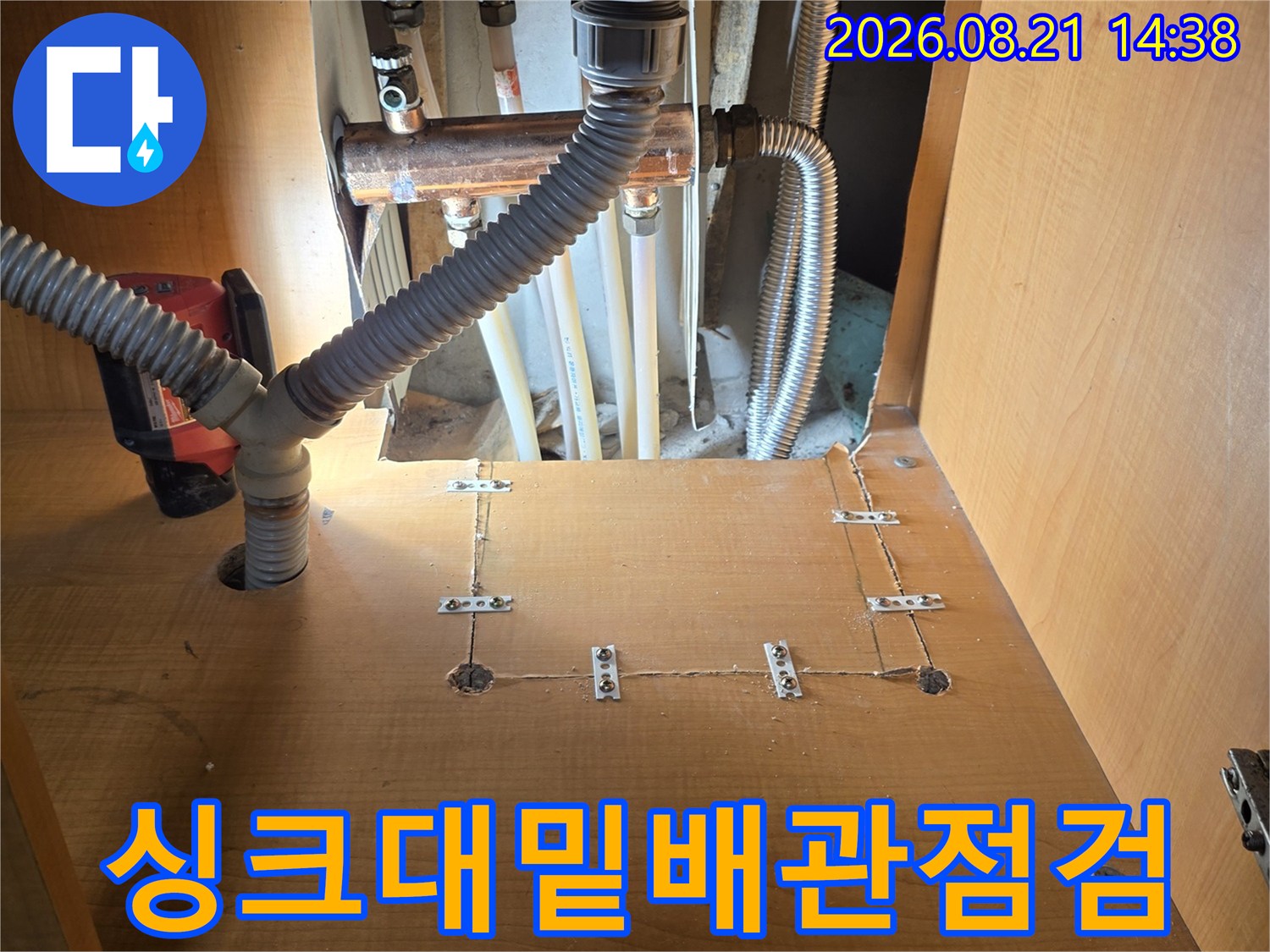 싱크대 하부의 금속 배관과 유연한 주름관 연결 부위 상세 사진