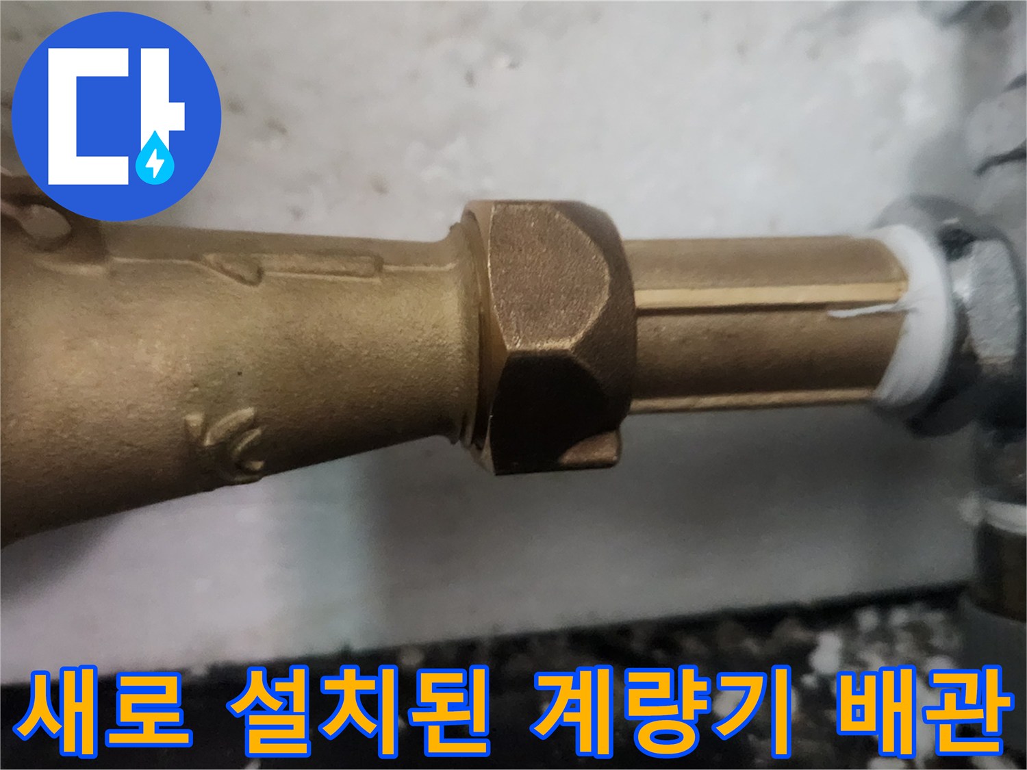 금속 재질의 새 수도 계량기와 연결된 은색 배관 모습입니다.