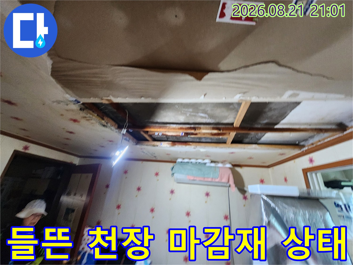 습기로 인해 부풀어 오르고 파손된 천장 마감재를 보여주는 사진입니다.