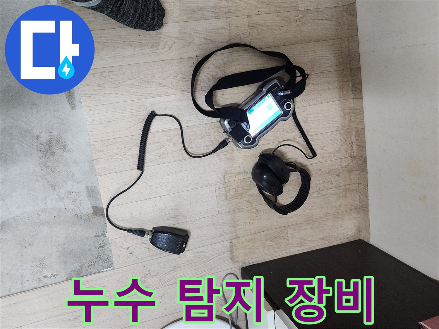 실내 바닥에 놓인 가스식 누수 탐지기와 헤드셋