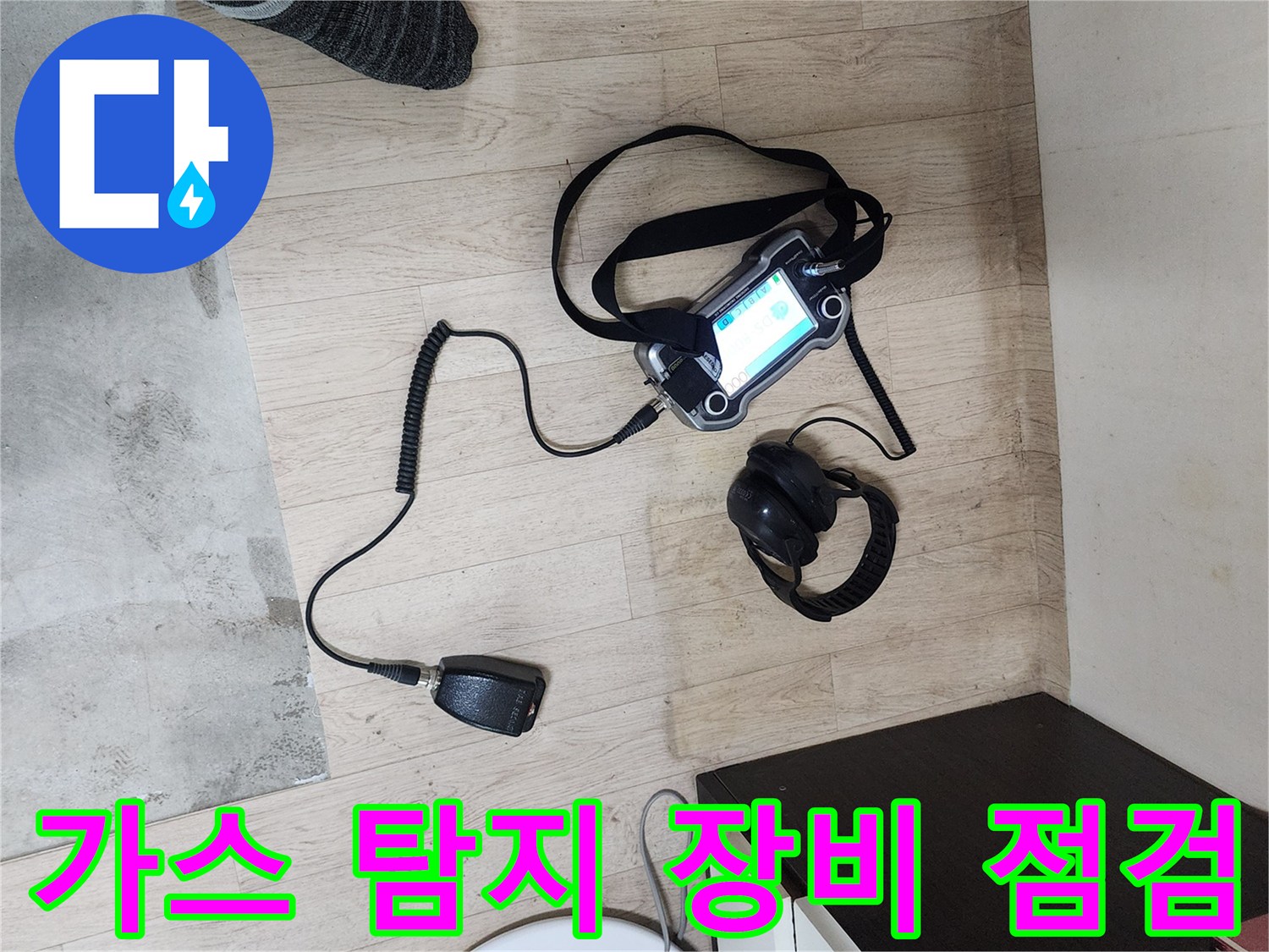 실내 바닥에 놓인 가스식 배관 탐지기 및 헤드셋