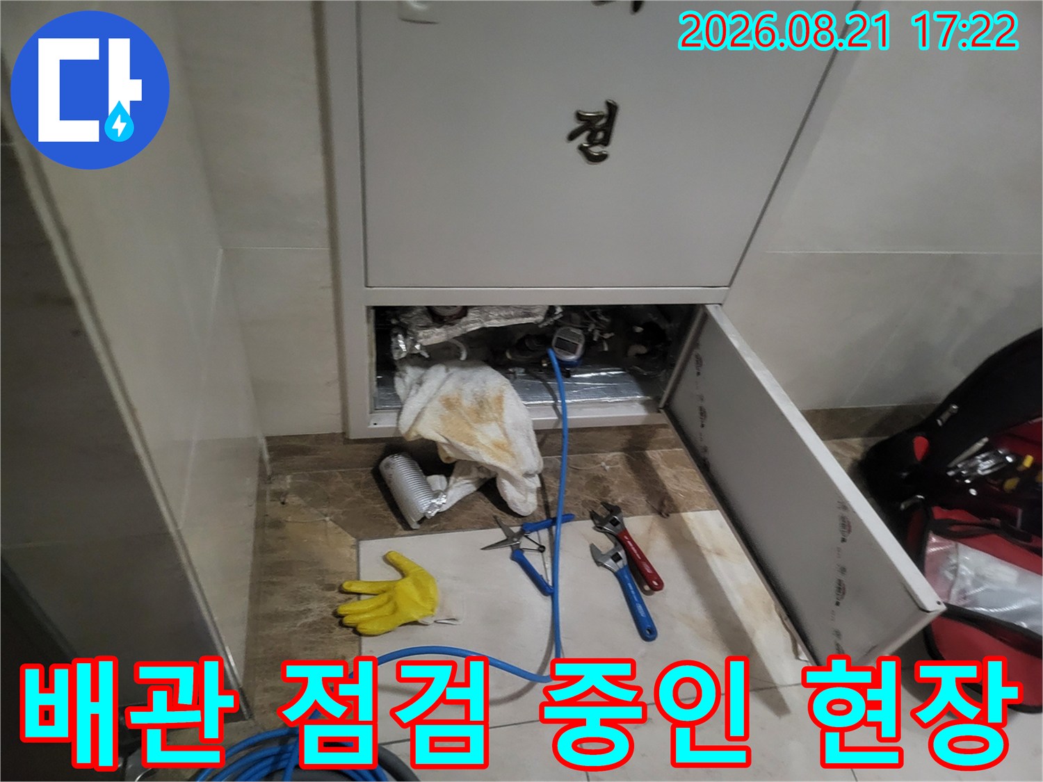 싱크대 하부장 내부-노출된 배관과 가스 탐지 호스