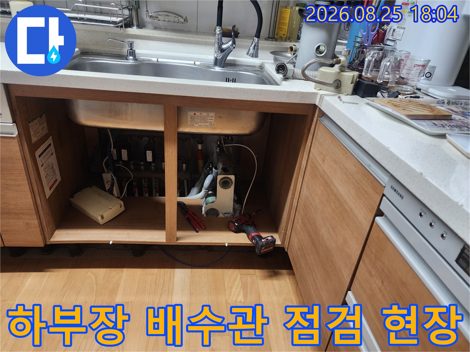 싱크대 하단 배수관 연결 부위의 누수 여부를 확인하기 위한 정밀 검사 장면