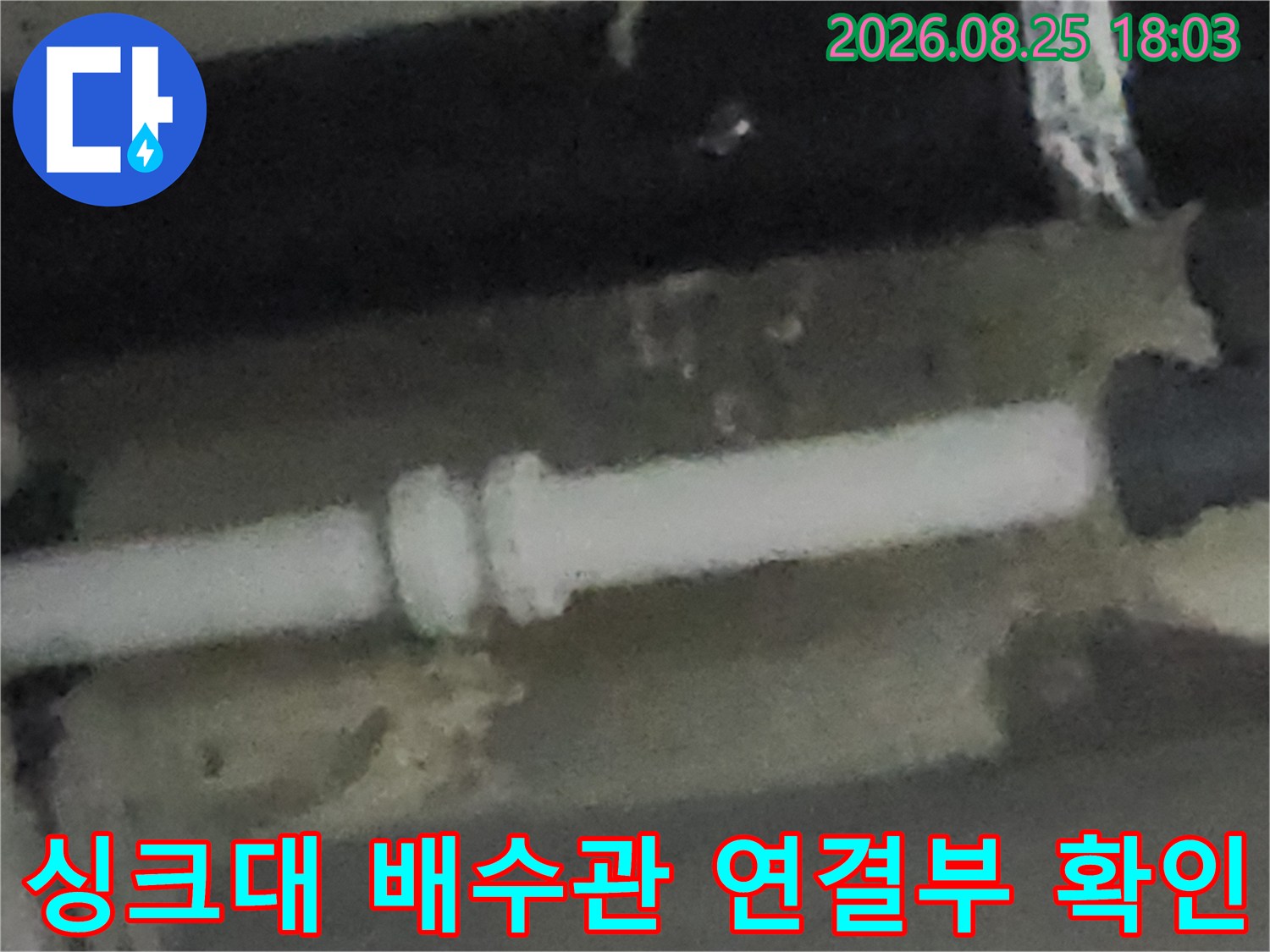 싱크대 하부장 내부의 흰색 배수관과 연결 부위 상태를 보여주는 사진입니다.