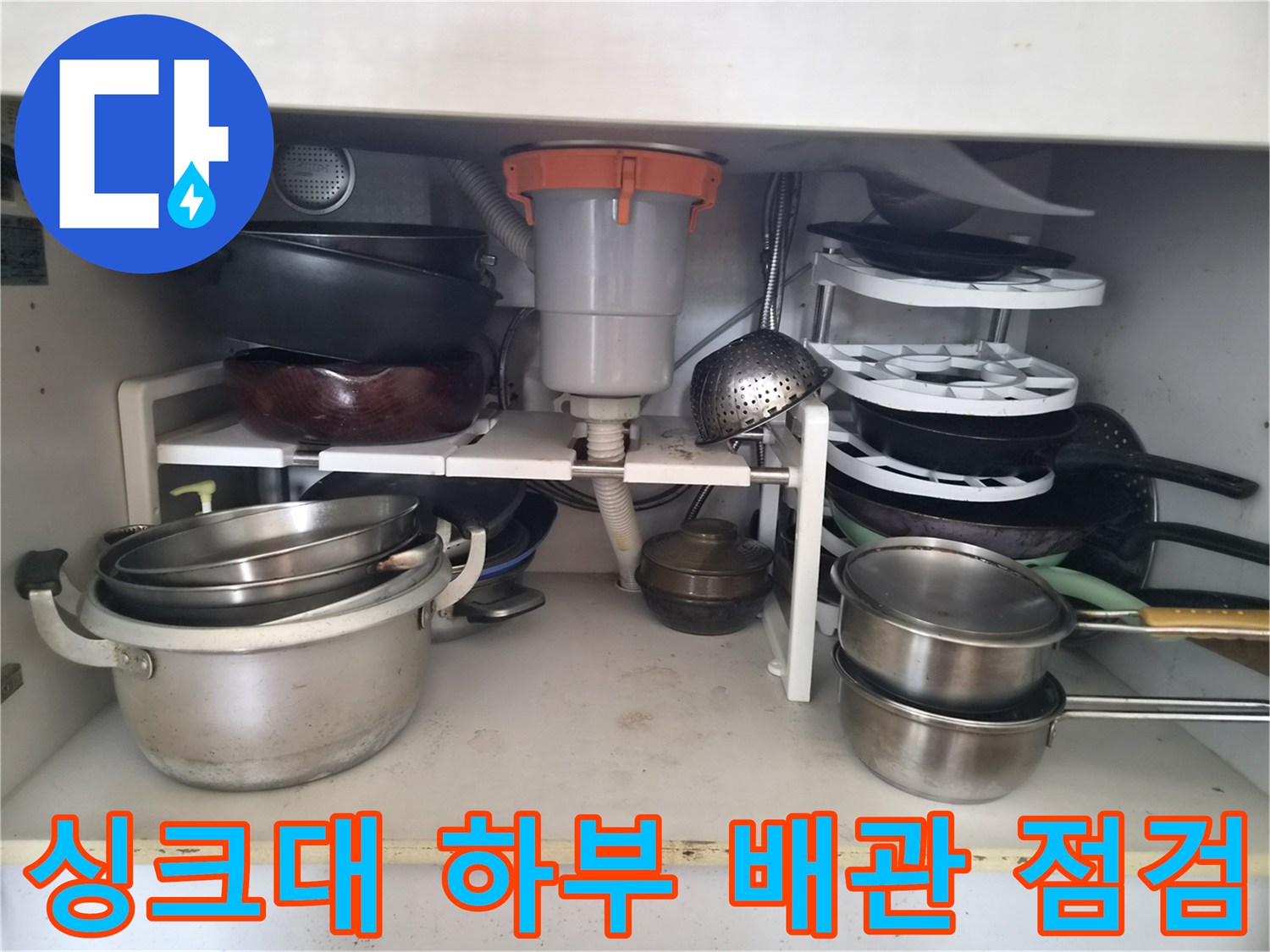 싱크대-하단-내부의-복잡한-배관과-주방용품