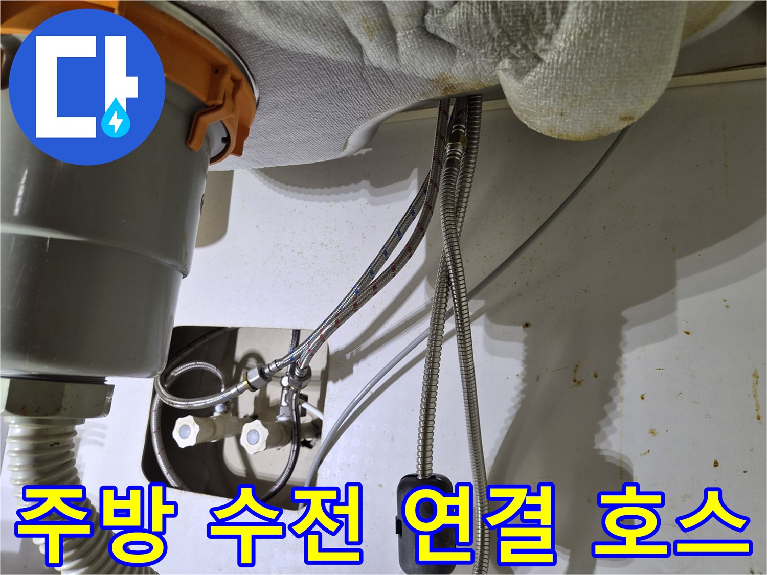 싱크대 하단부의 은색 고압 호스와 냉온수 조절 밸브 근접 촬영