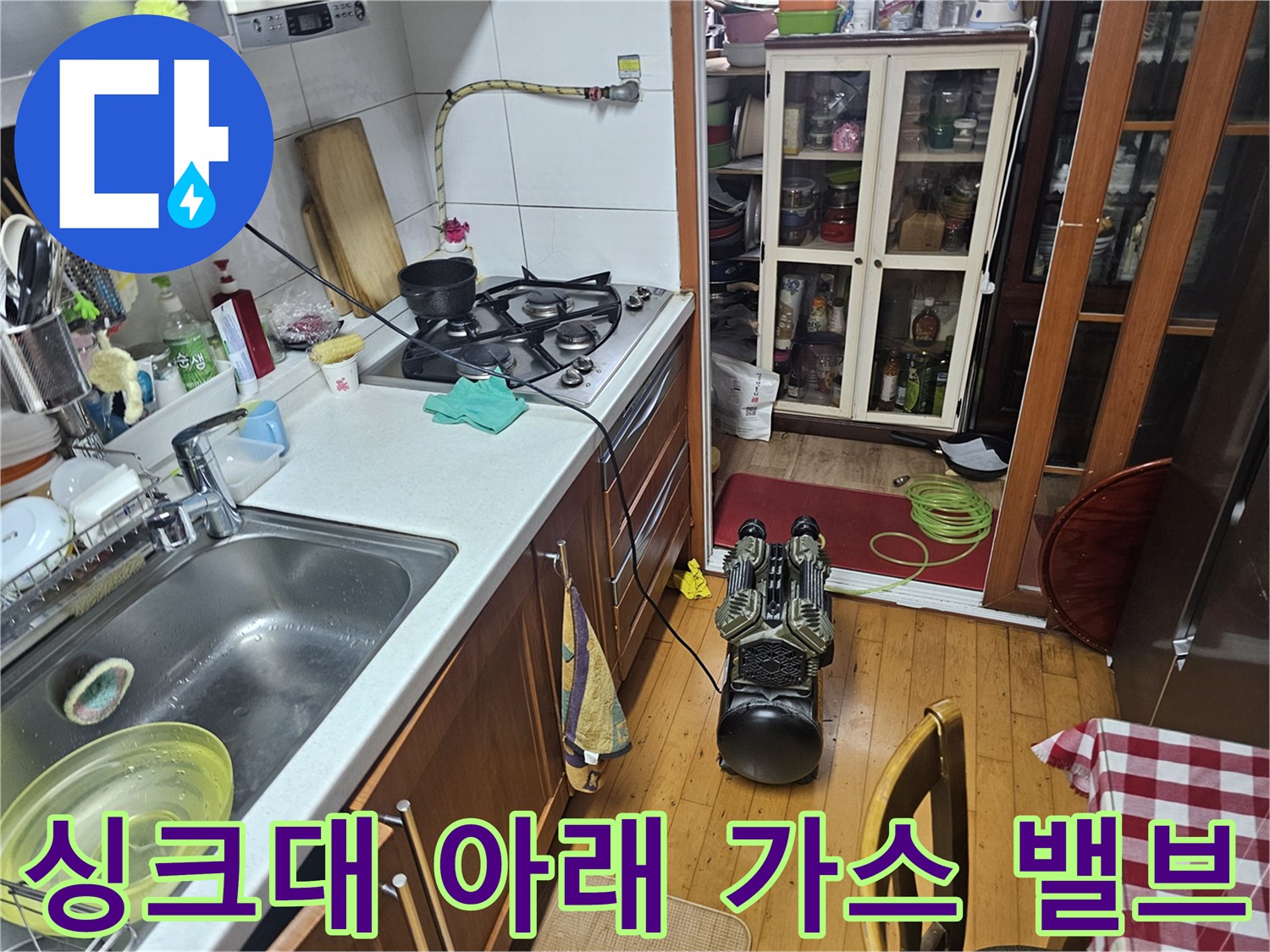 주방 싱크대 하단에 위치한 가스 밸브와 수도 부품들입니다.