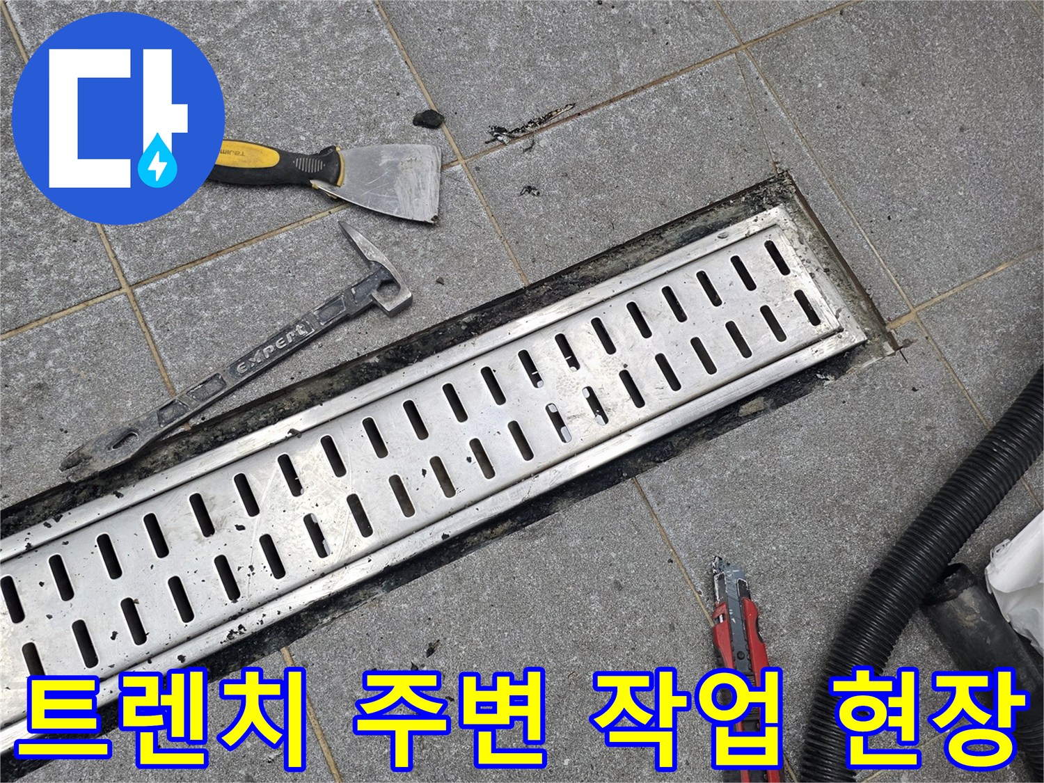 배수 트렌치 덮개와 함께 놓여 있는 수리용 도구의 모습입니다.