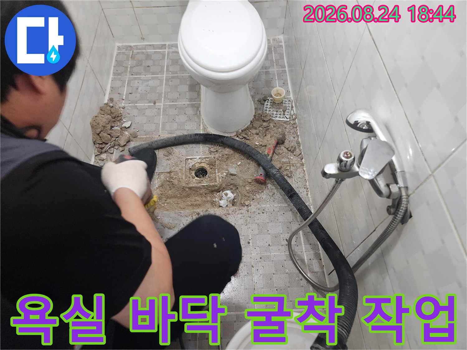 변기 옆쪽 타일을 제거하고 배관을 찾아낸 욕실 공사 현장 모습입니다.