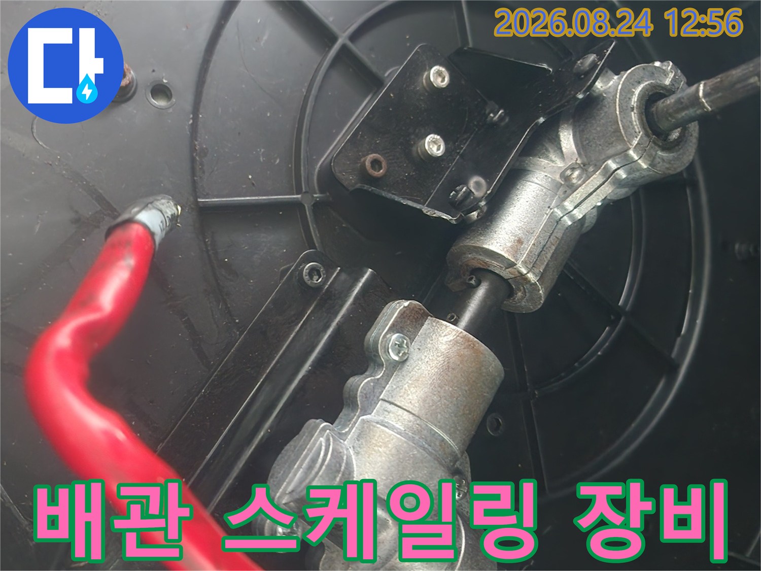 금속 샤프트와 빨간색 호스가 연결된 배관 청소용 장비 세팅