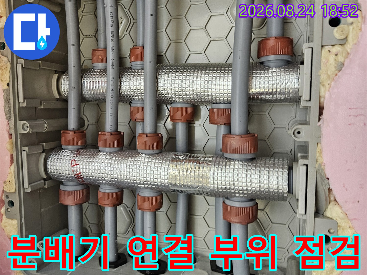 갈색 커플링으로 연결된 여러 갈래의 은박 보온재 배관 모습입니다.