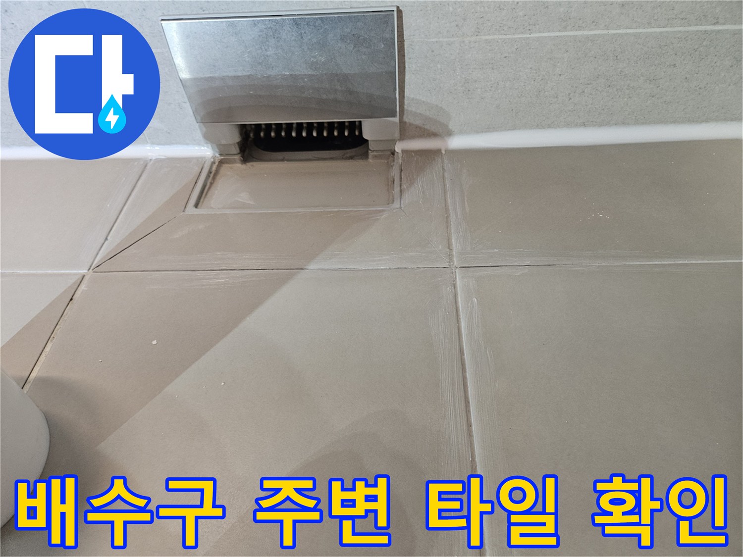 스테인리스 배수구와 인접한 베이지색 타일 마감 상태