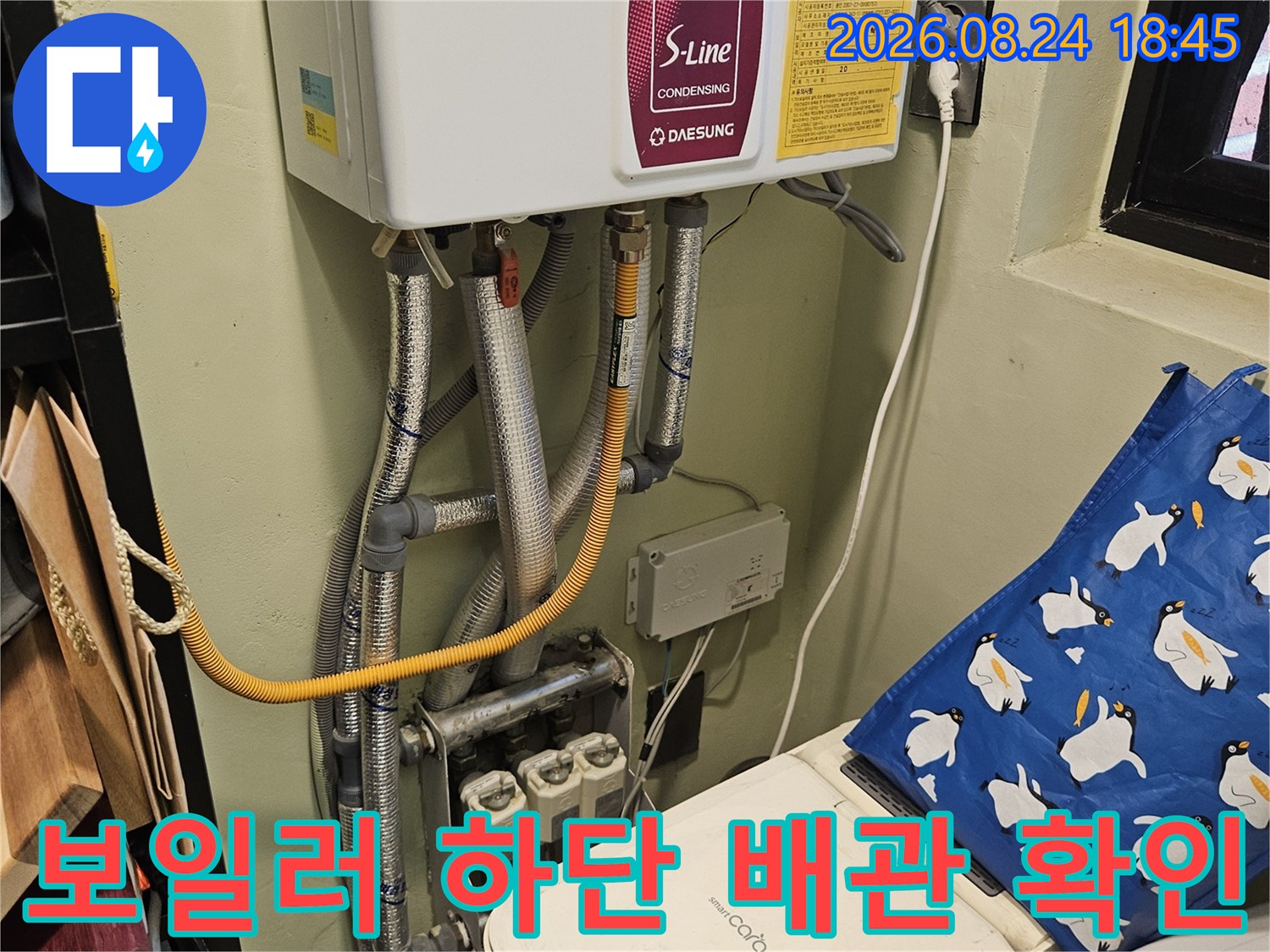보일러와 은색 보온재가 씌워진 배관들의 모습입니다.