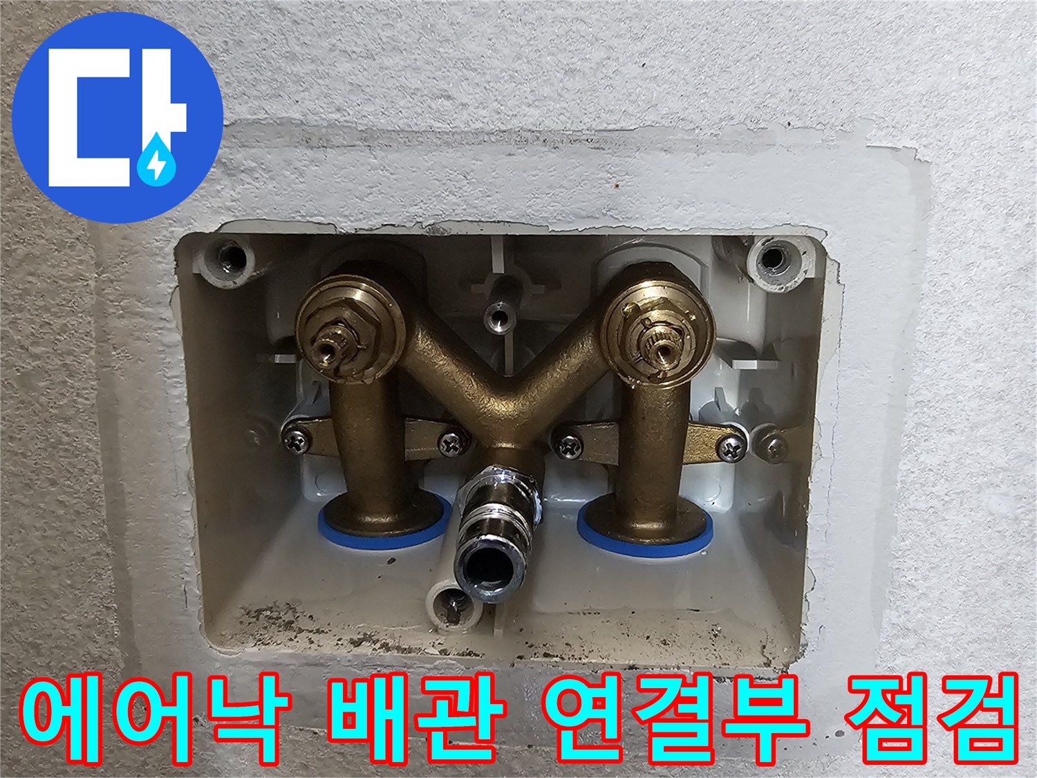 벽면 개방 부위-황동색 밸브와 배관 연결 상태를 촬영한 사진