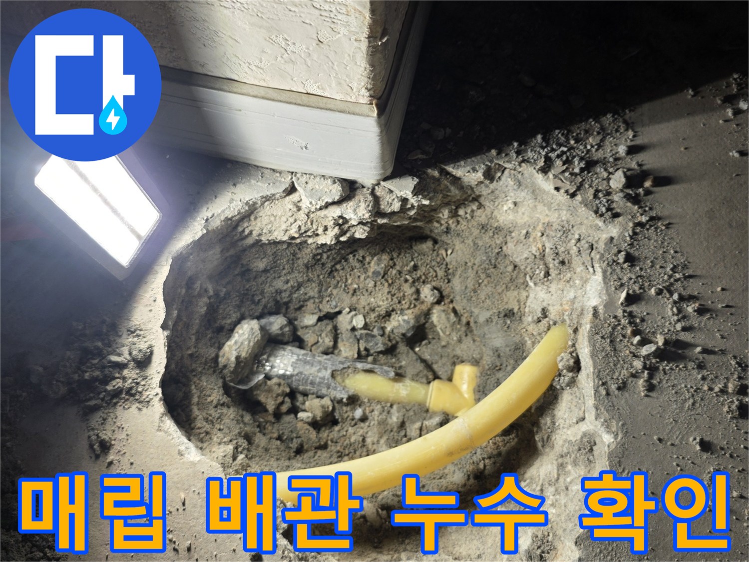 콘크리트 층 아래 노출된 노란색 배관의 누수 구간