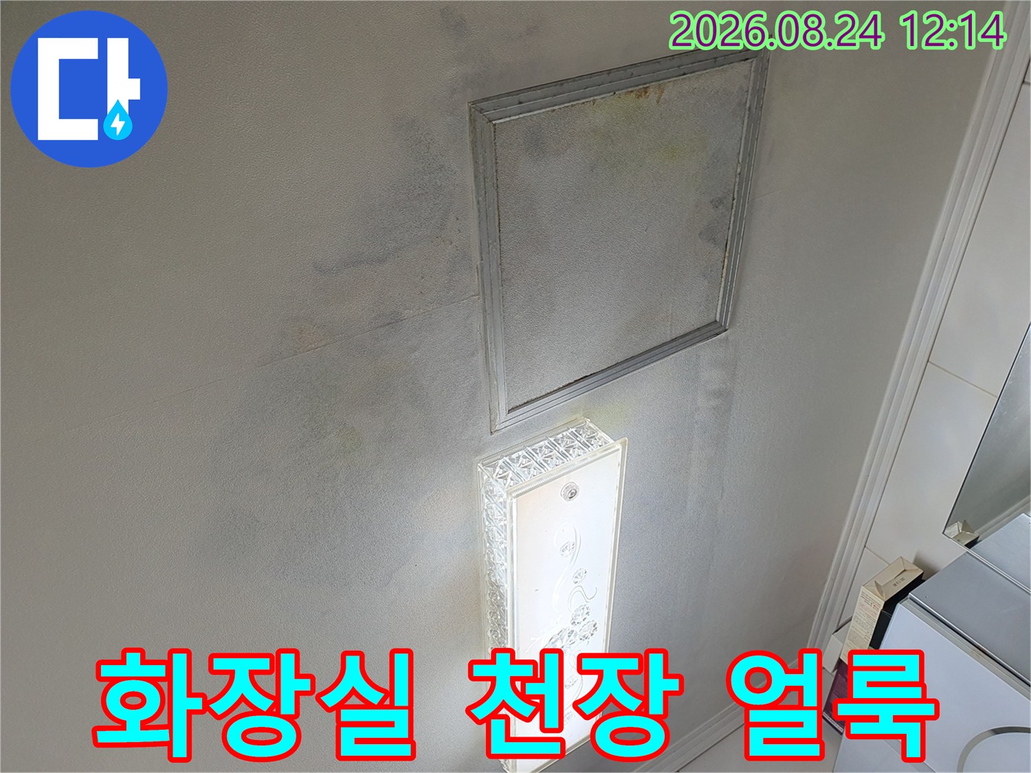 거울 주변에 넓게 퍼진 화장실 천장 누수 흔적과 변색된 얼룩 상태입니다.
