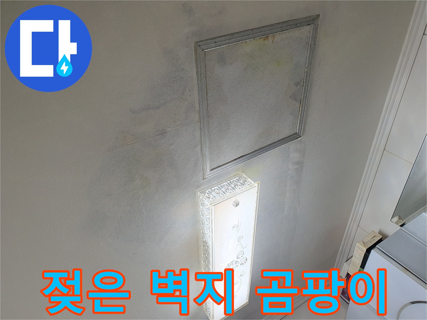 화장실 거울 아래로 번진 습기와 벽지 오염 상태를 보여주는 사진