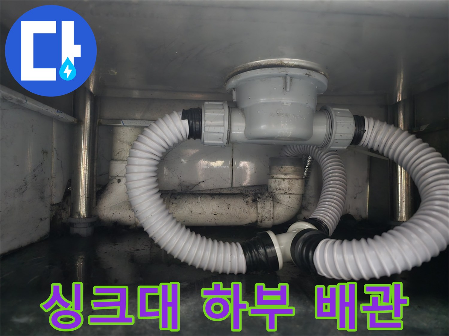 깨끗하게 정비된 싱크대 하단부의 배수관 연결 모습입니다.