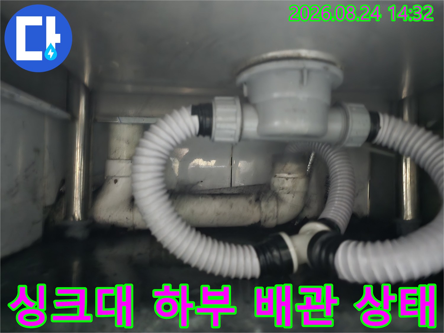 식당 싱크대 아래쪽 PVC 배관과 주름진 배수 호스의 연결 구조