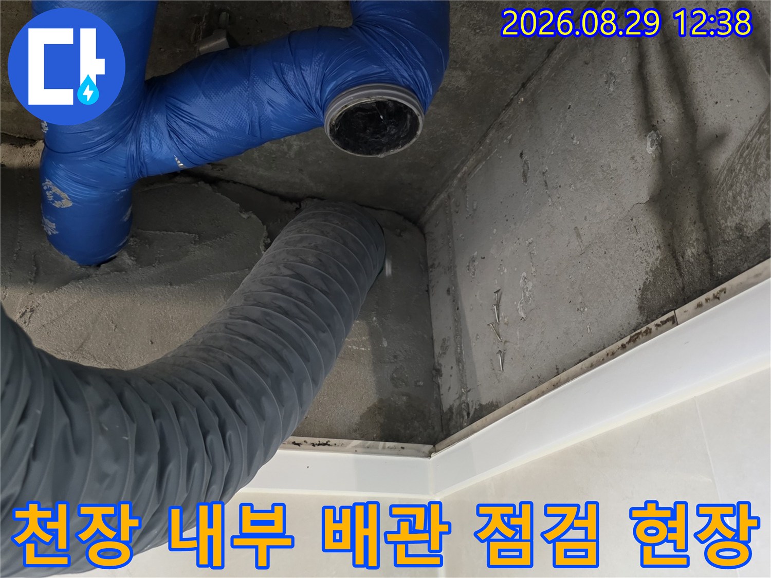 파란색 유연한 호스와 회색 자재가 보이는 천장 안쪽