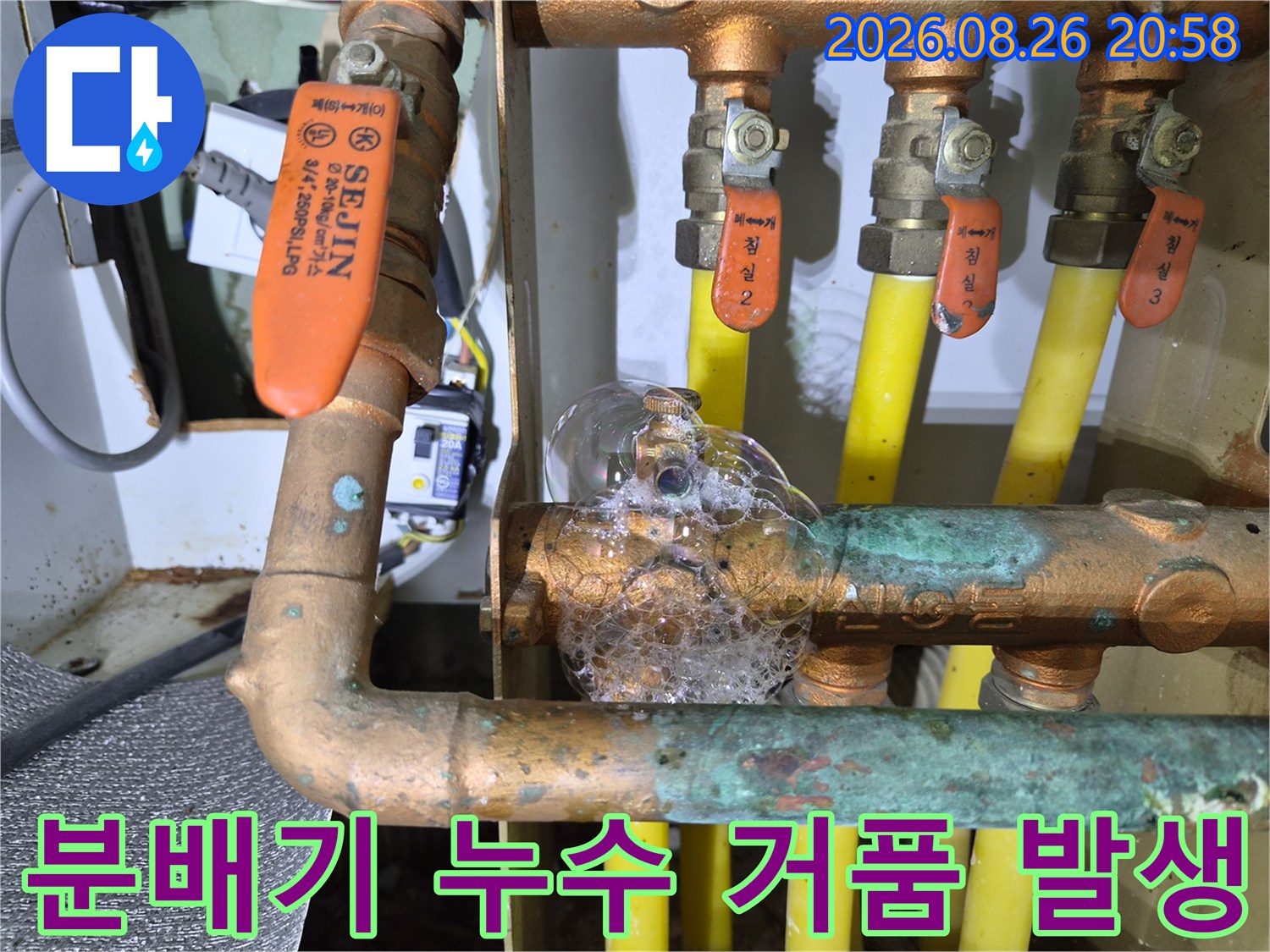금속 배관 연결 부위에 비눗물 거품이 맺혀 있습니다.