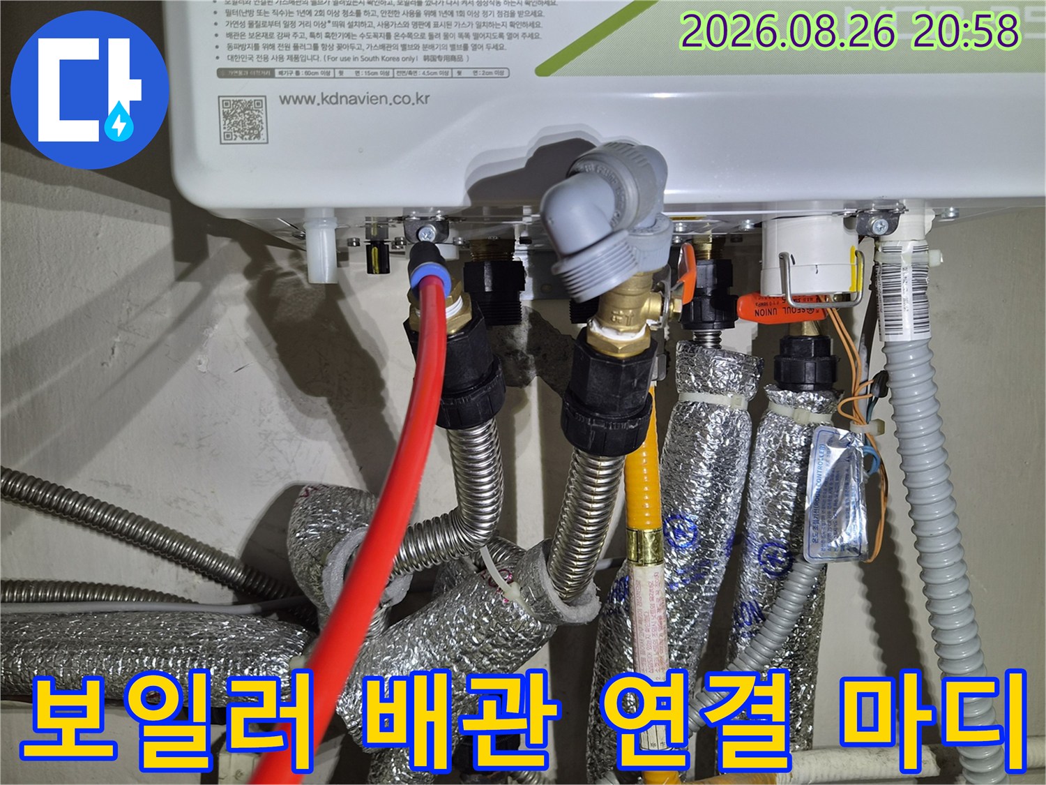 보일러 하단의 금속 부품과 호스 연결 부위 상세 촬영