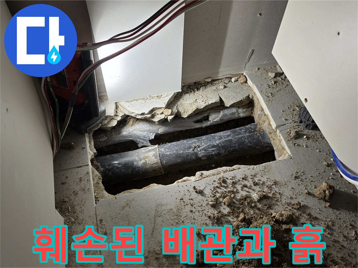 싱크대 아래 굴착 부위의 파손된 배관과 젖은 흙의 모습