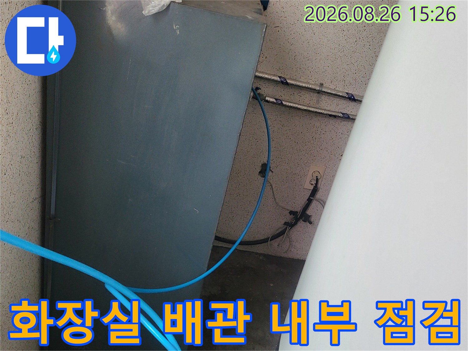 화장실 하부 공간의 오수 배관과 파란색 탐지 호스 모습