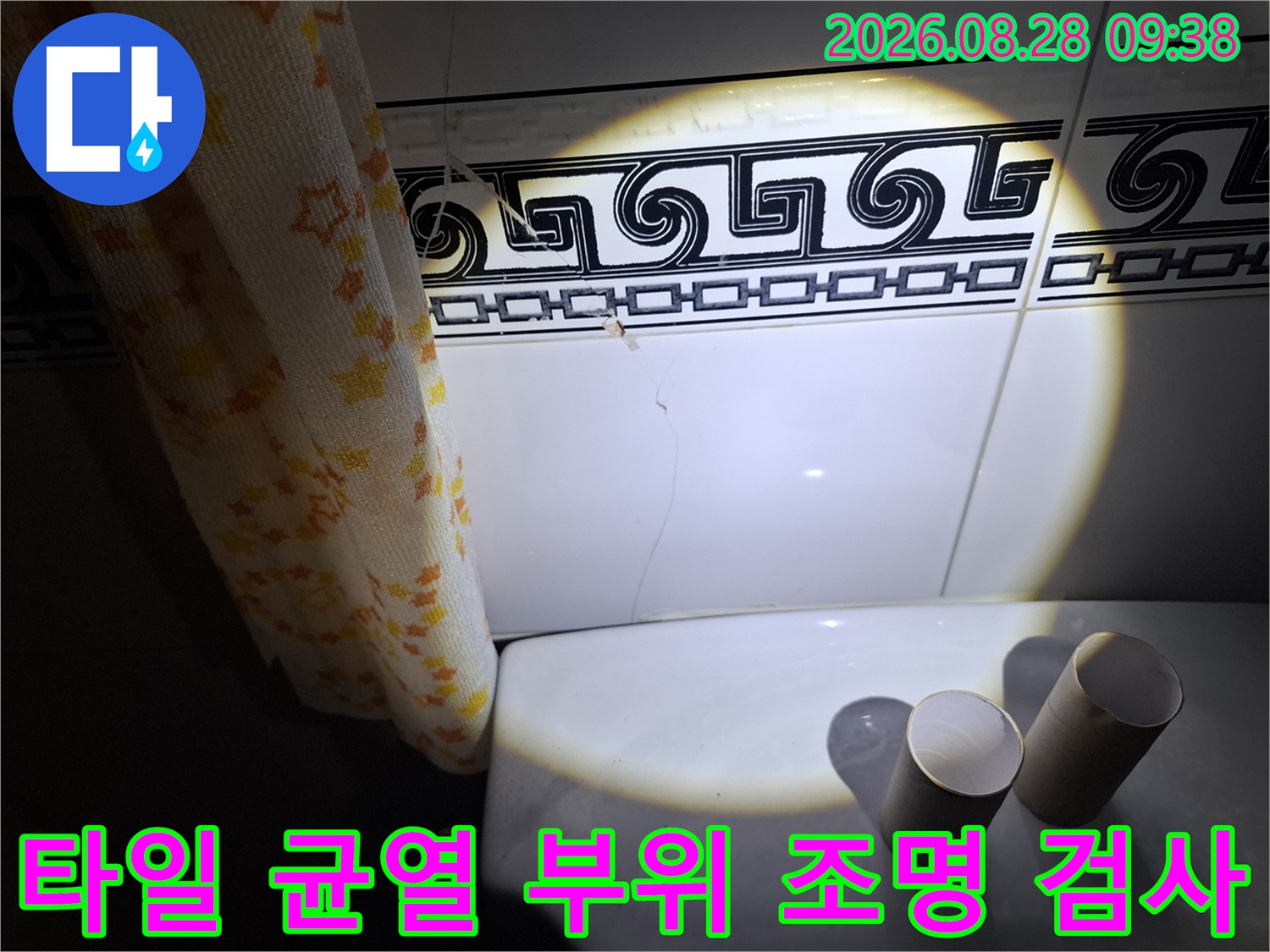 조명을 활용하여 벽면 타일의 수직 균열을 정밀하게 촬영한 사진