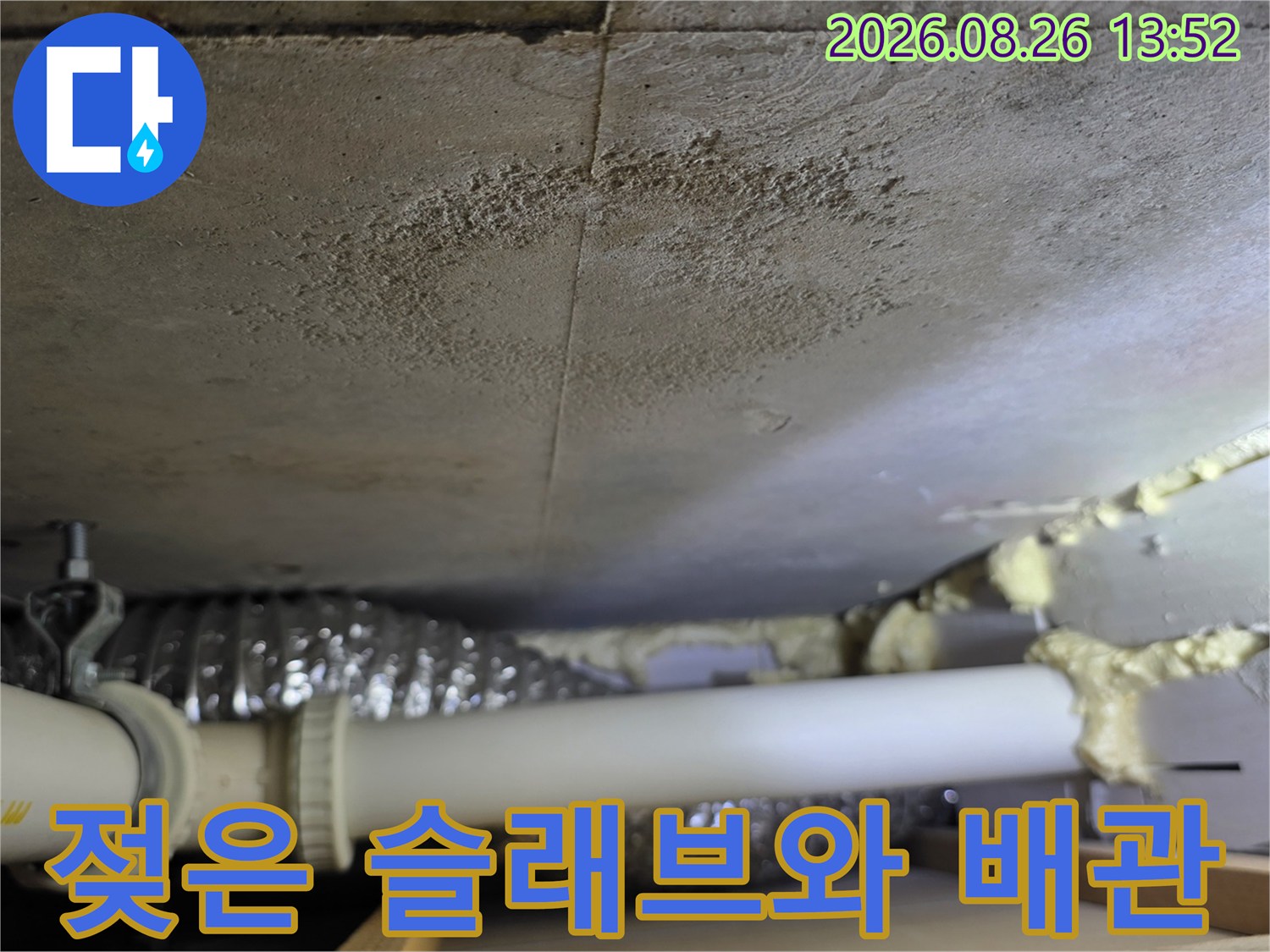 천장 내부의-물에 젖은 콘크리트 면과 노출된 배관 구조